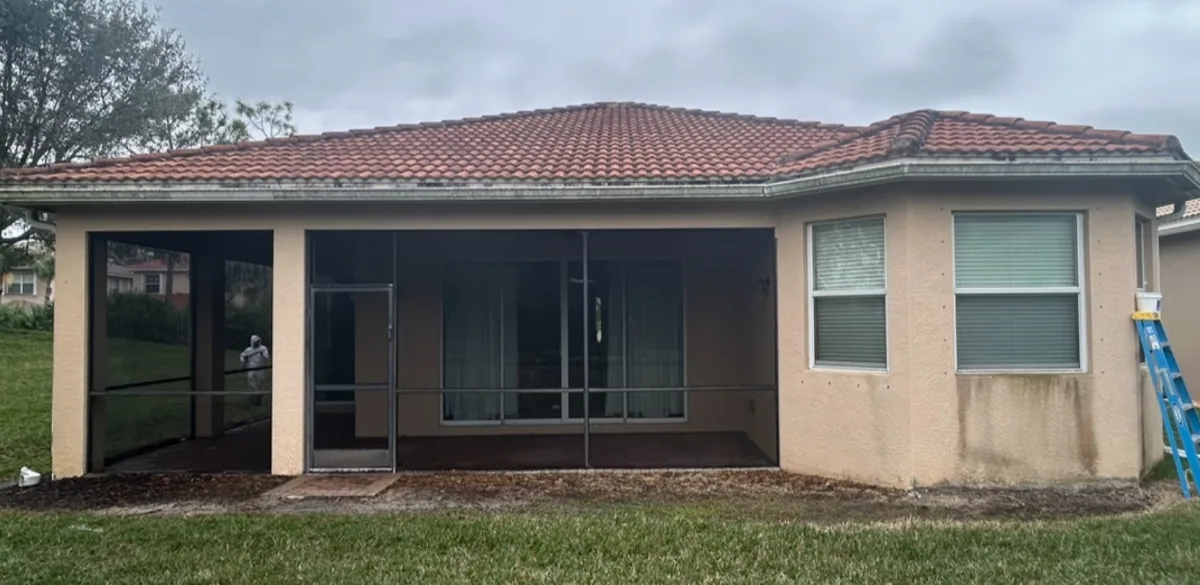 Weathered tan home rear elevation before repaint in Fort Myers FL